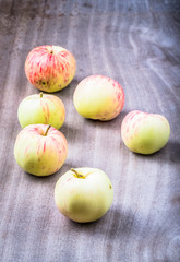 Yellow-red seasonal apples on the background of old boards. Tone