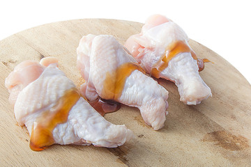 raw chicken legs on wooden cutting boards on white background