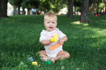 Toddler kid girl playing wooden cubes in green