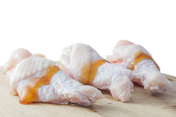 raw chicken legs on wooden cutting boards on white background