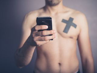 Young shirtless man with smartphone