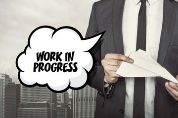 Work in progress text on speech bubble with businessman holding