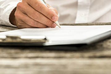 Closeup low angle view of male hand signing subscription form, l