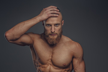 Fototapeta premium Muscular man with beard posing in studio.