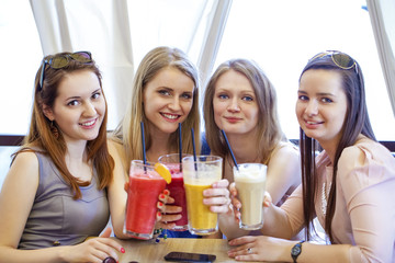 Four young girls have a rest in a summer cafe