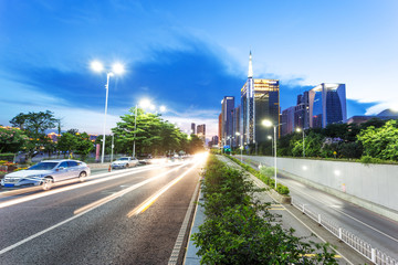 skyscrapers of a modern city at dusk with street lamps