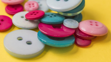 Sew buttons on a yellow background