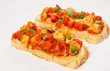 tomato bruschetta with chopped vegetables, herbs, cheese and chicken on ciabatta bread
