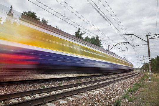 Fototapeta passenger train on railroad tracks in speed motion