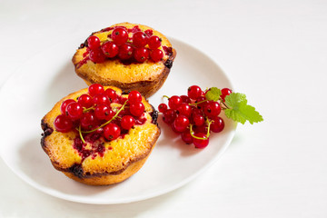 Delicious cakes with red currant on a plate