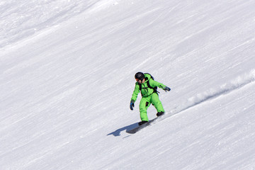 Fototapeta na wymiar Snowboarder going down the slope at ski resort.