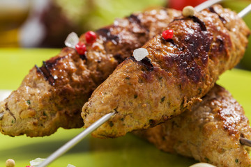 Barbecued kofta - kebeb with vegetables on a plate.