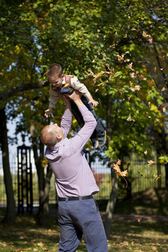 Little boy and father in autumn park