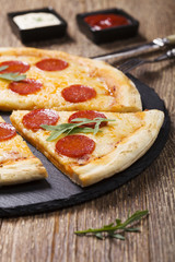 Pizza peperoni on stone black try with rocket and mozzarella che