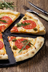 Pizza vegetarian on plate on stone black try with fresh tomatoes
