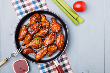 Baked chicken wings in honey sauce sprinkled with sesame seeds.