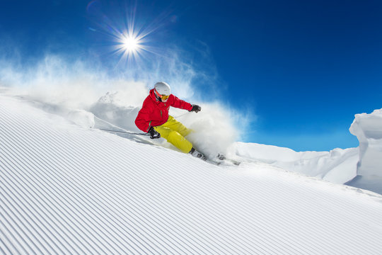 Skier skiing downhill in high mountains