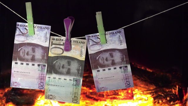Falschgeld trocknet auf Leine vor dem Kaminfeuer
