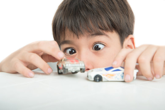 Little boy playing with car toy on  the table