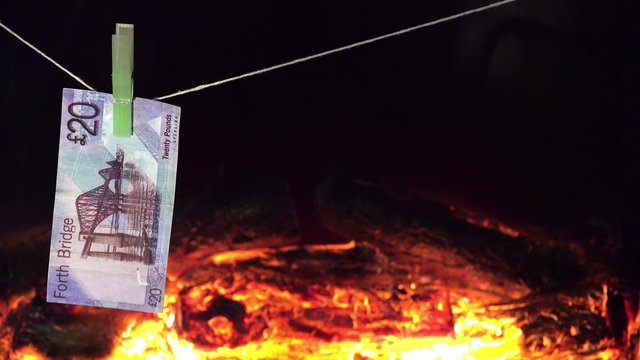 Falschgeld trocknet auf Leine vor dem Kaminfeuer