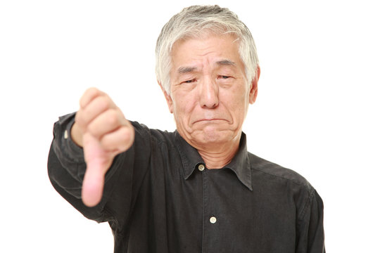 Senior Japanese Man With Thumbs Down Gesture