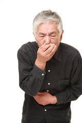 senior Japanese man holding his nose because of a bad smell