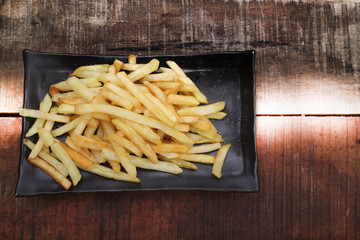 Fresh fried french fries with ketchup on wooden background