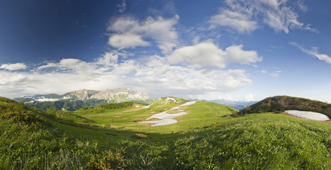 panorama of summer snow mountains with big grass valley