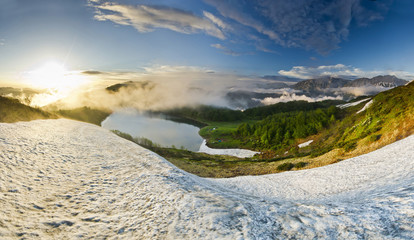 blue mountain lake surrounded by high peaks at sunset