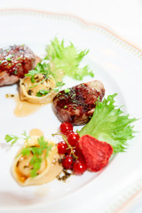 Duck meat with berries and ravioli