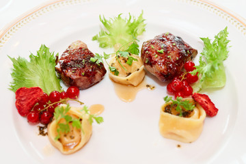 Duck meat with berries and ravioli