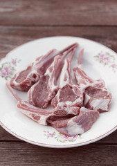 Raw rack of lamb on vintage plate