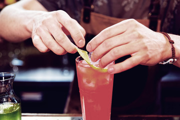 Bartender is adding zest to the cocktail