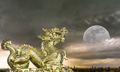 Golden dragon sculpture and full moon sky