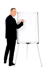 Male executive writing on a flipchart