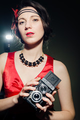 Romantic beautiful girl in 1920s styled costume holding retro