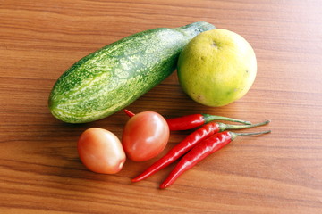 Lemon pepper, tomato, cucumber, put on the wood floor.