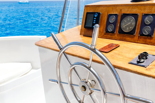 Sailing yacht control wheel and navigation implement.