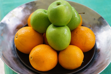Orange and green apple on a tray