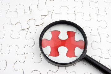 Magnifying glass on a missing puzzle piece. Selective Focus.