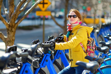 Naklejka na ściany i meble Young woman ready to rent a bike in New York