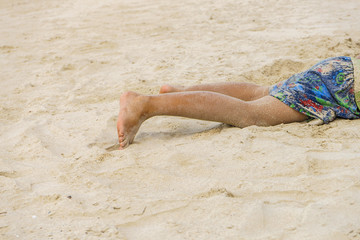 Children legs when he lay down on the beach