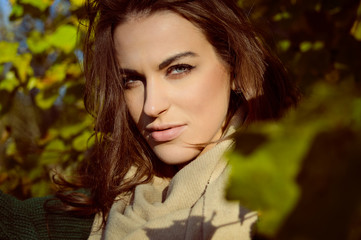 Naklejka premium Charming woman in beige scarf smiling on sunny outdoor