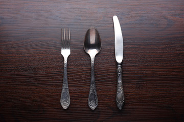 Fork, spoon and knife on wooden table