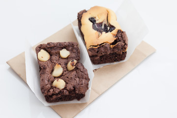 Chocolate brownie with macadamia on white background.