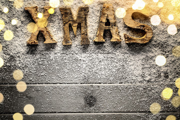 Rustic wooden letters spelling Xmas on snow