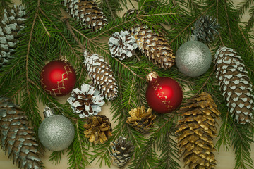 New Year festive decorative background. Christmas tree branch with Christmas toy balls, Christmas tree cones