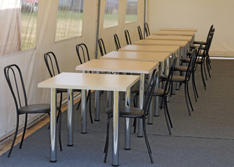 tables and chairs in the dining room in the tent camp.