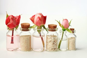 Roses and sea sand in corked glass little bottles, romantic tranquil relaxing home spa decor, blank space