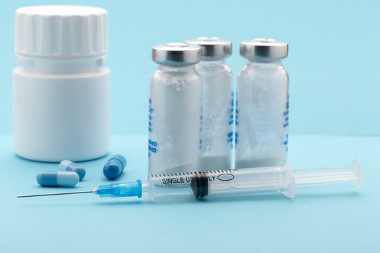Healthcare and medicine concept.Syringe,pills bottle on blue
